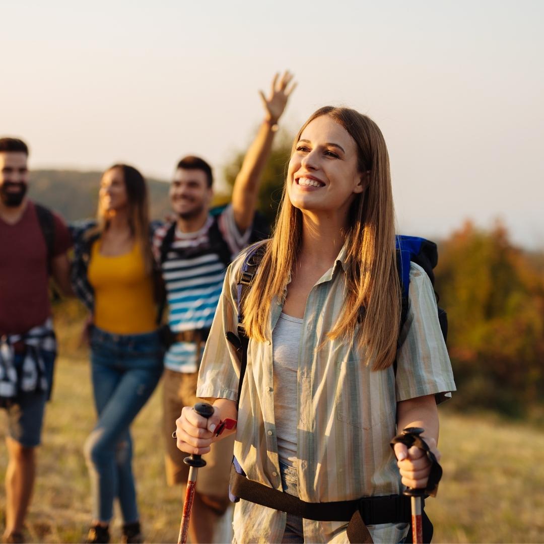 happy friends watching the sunset on a hike